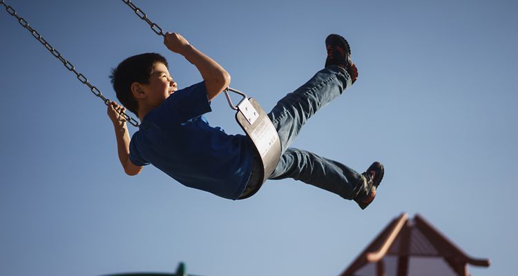 photo of boy on swing