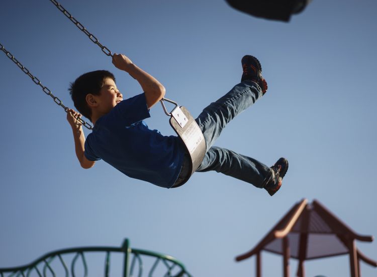 photo of boy on swing