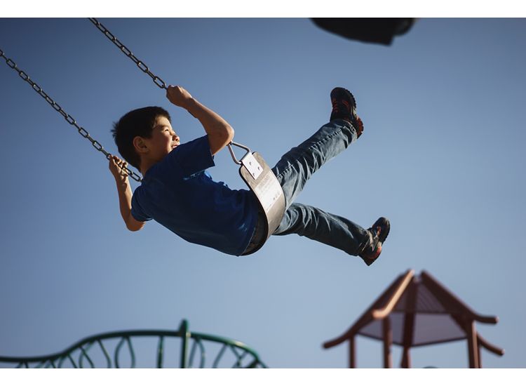 photo of boy on swing