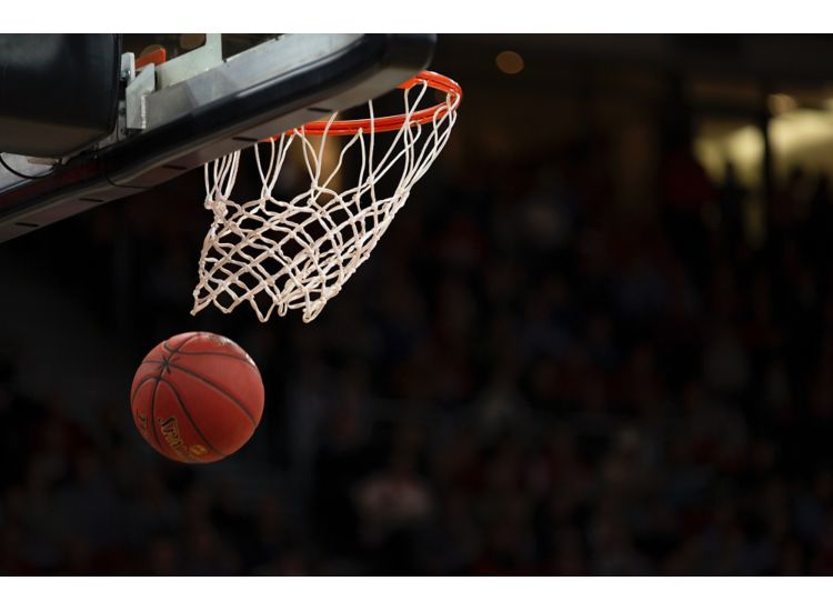 Close up of a basket ball going through a hoop.