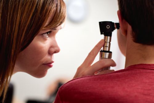 Un audiologiste-chercheur examine un patient atteint d'un cancer pédiatrique.