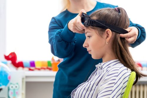 Young teenage girl and child therapist during EEG neurofeedback session