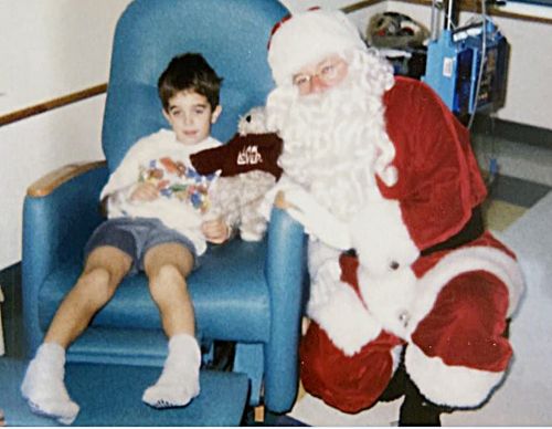 Brad Muller as a child sitting with Santa Claus