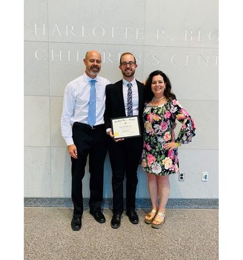 Brad Muller y sus padres en la ceremonia de graduación