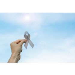 Woman holding gray ribbon for Brain Tumor Awareness Month