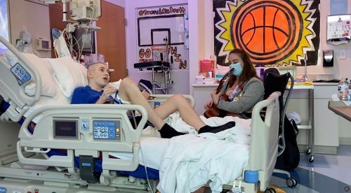 A music therapist playing guitar with Brett