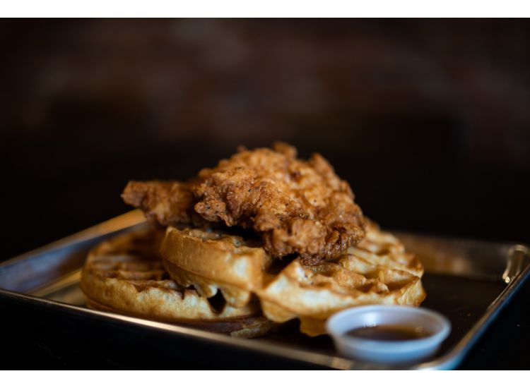 Stock photo of waffles and chicken on a metal tray