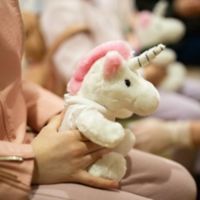 Child holding stuffed unicorn