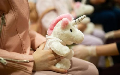 Child holding stuffed unicorn