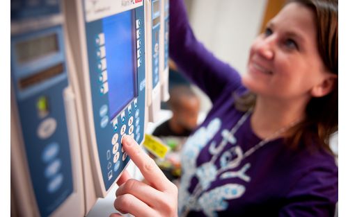 Nurse adjusts settings for patient monitor 