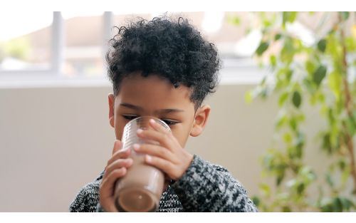 Little boy drinking chocolate milkshake.