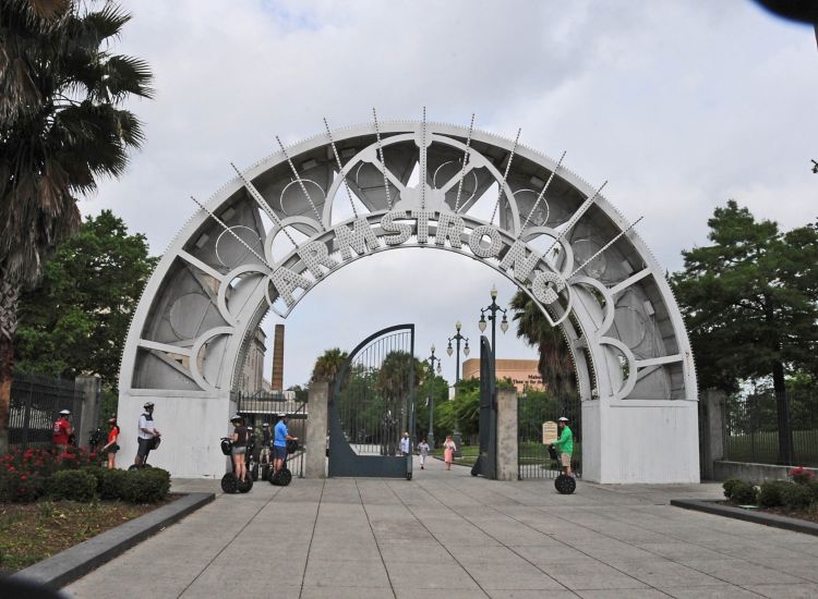 Large silver archway reading "Armstrong" over a pathway into a park.