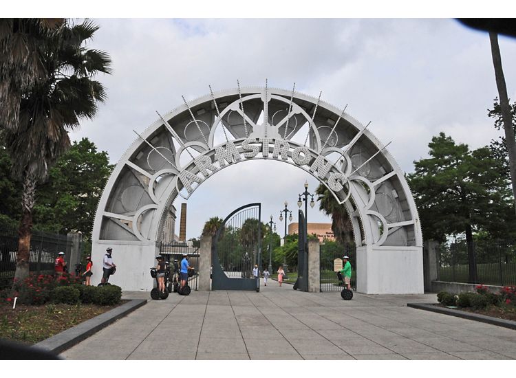 Large silver archway reading "Armstrong" over a pathway into a park.