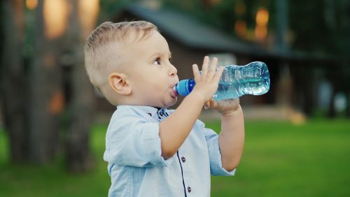 Niño pequeño bebiendo de una botella de agua