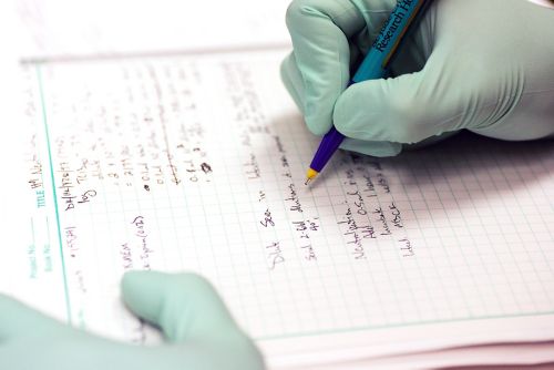 Researcher writing in a notebook