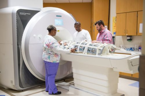 فريق طبي يساعد على إجراء فحص تصويري تشخيصي.