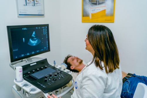 Female ultrasound technician conducting ultrasound on male patient