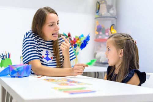 Un patólogo del habla y del lenguaje hablando con un niño