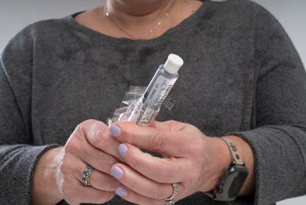 Woman opens saline syringe