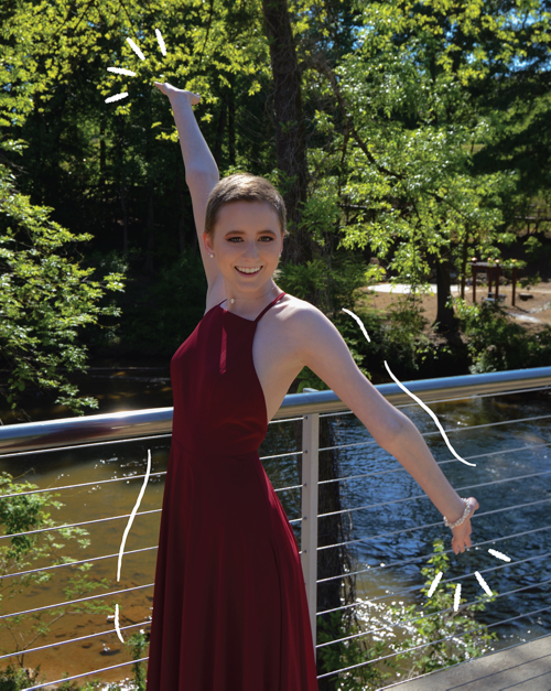 Elizabeth standing on a bridge with her arms spread apart.