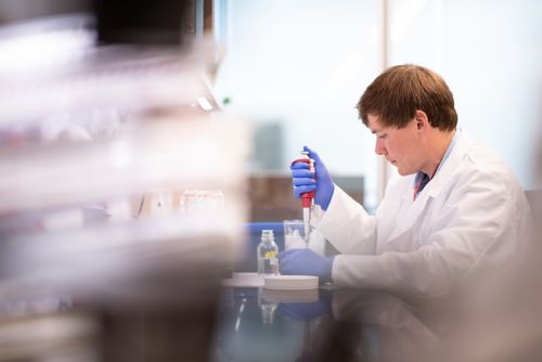 Male in white lab coat working 