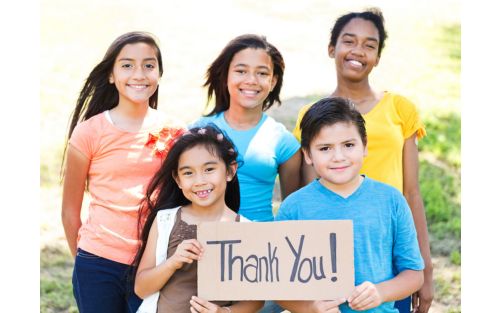 A group of kids holding a sign that says thank you