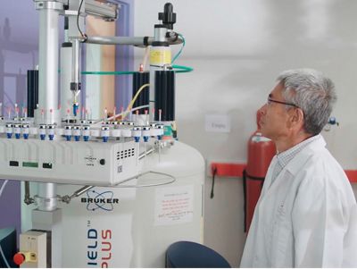 man in white coat working at machine