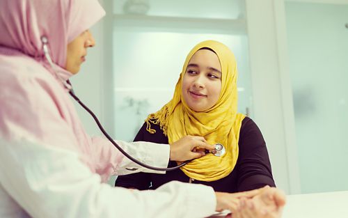 Doctor with stethoscope checking out patient