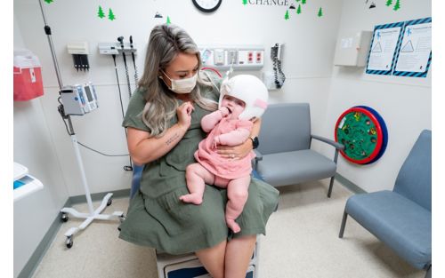 Mother holding baby in hospital room