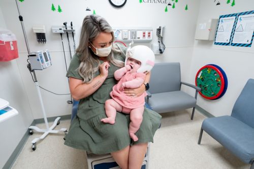 Madre sosteniendo a un bebé en una habitación de hospital