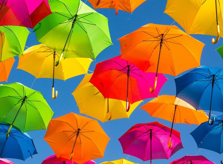 View from below of very colorful umbrellas suspended in the air