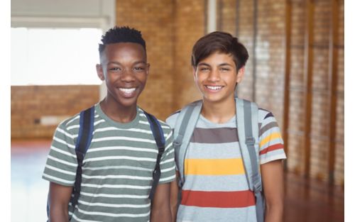 Two teen boys smiling and wearing backpacks