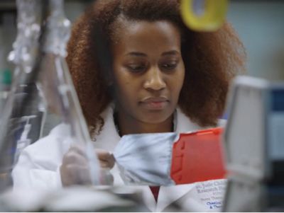 woman in white coat working in lab