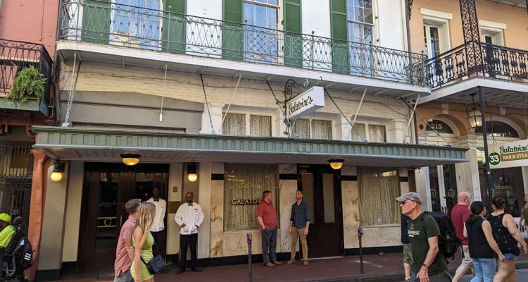 Exterior of Galatoire's Restaurant, a white building with green shutters in New Orleans French Quarter.