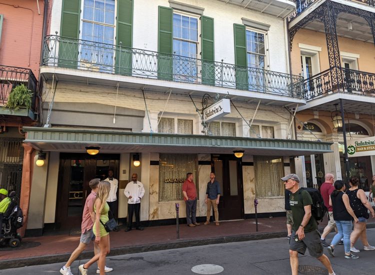 Exterior of Galatoire's Restaurant, a white building with green shutters in New Orleans French Quarter.