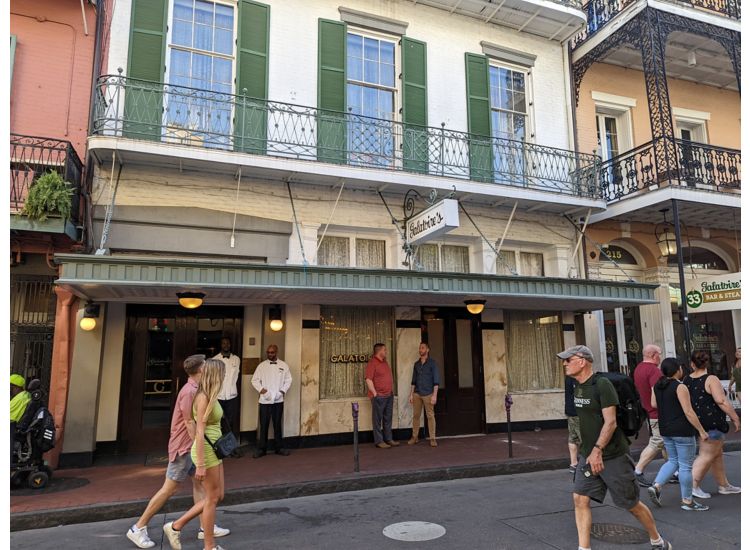 Exterior of Galatoire's Restaurant, a white building with green shutters in New Orleans French Quarter.