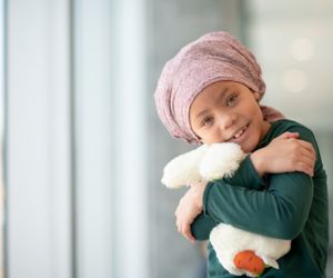 Girl with head scarf holding teddy bear
