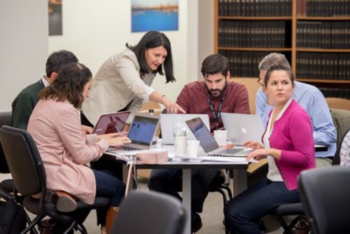 Photo of group of people working at a table.