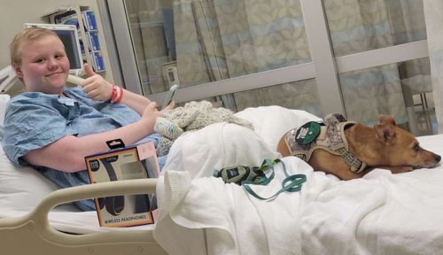 Grace and her dog Peanut in hospital bed