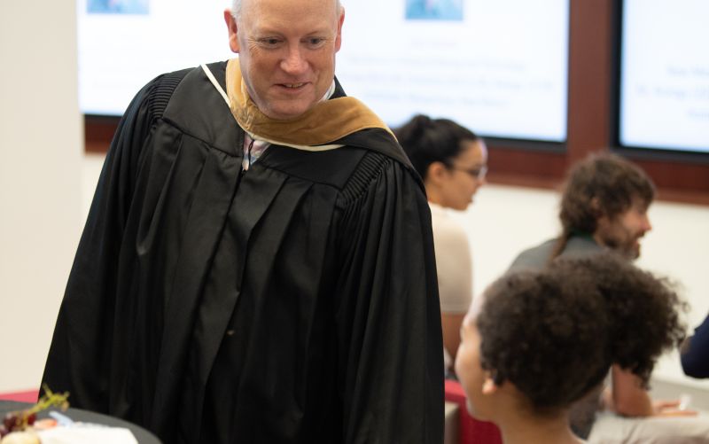 Man in robe talking to young girl.