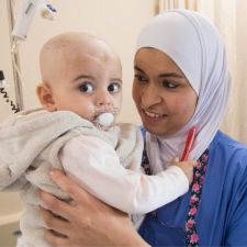 Nurse holding child cancer patient. 