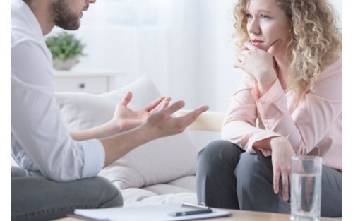 Man talking with female counselor, while both are sitting