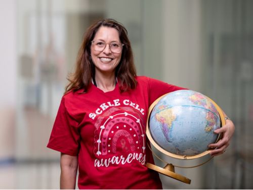 image of woman in red tshirt holding a globe