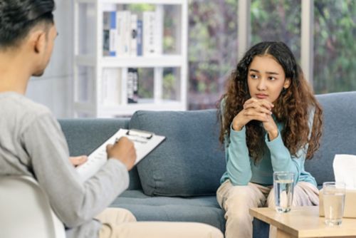 Woman speaking with man with clipboard.