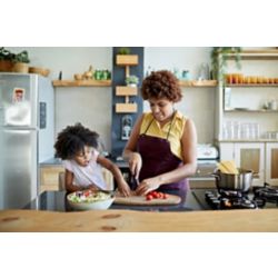 Girl and mother cooking healthy foods in the kitchen together