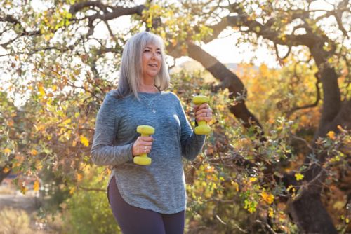 Woman walking while holding dumbbells