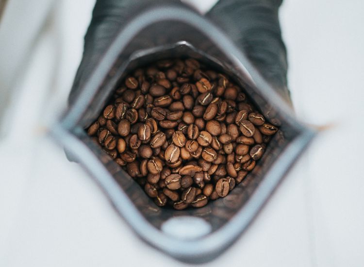 photo of two hands holding a bag of coffee beans