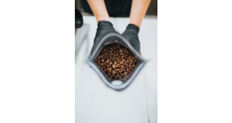 photo of two hands holding a bag of coffee beans