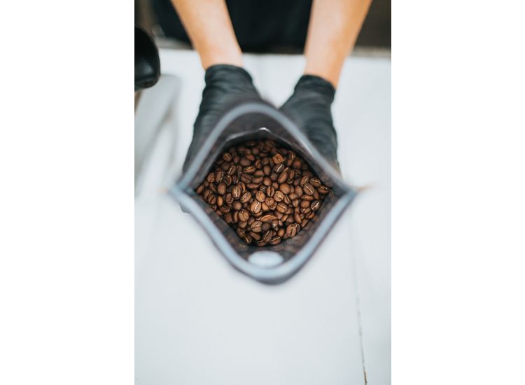 photo of two hands holding a bag of coffee beans