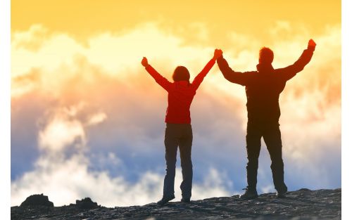 image of two people with arms raised